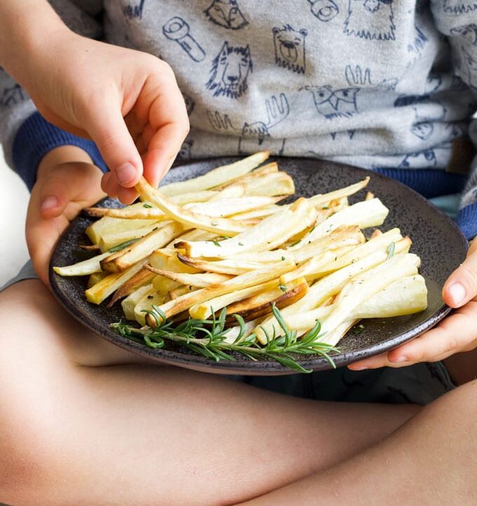 Child Grabbing a Roasted Parsnip from a plate